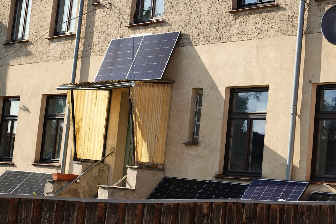 Solar panels mounted on a garden fence and over a doorway.